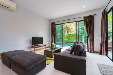 Interior design of house, home and villa feature sofa, television, sliding door and curtain in living room with pool view