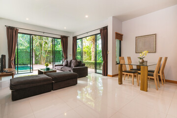 Interior design of house, home and villa feature sofa, dining table, chair, sliding door and curtain in living room with pool view