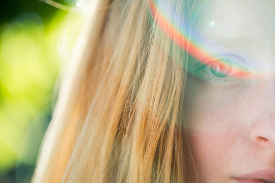 Close up of a girl with rainbow reflection on the eye