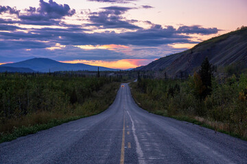 Scenic Road View of Klondike Hwy during a sunny and colorful sunset. Taken North of Whitehorse, Yukon, Canada.