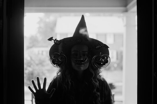 A woman dressed as a witch at the front door