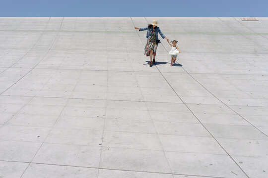 Mother and daughter running on a cement slope