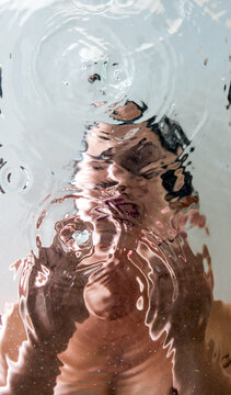 Woman hashing her face in water, point of view