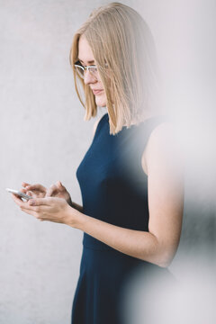Happy businesswoman sending a message with smartphone on the street