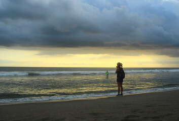 A woman take a photo at Petitenget beach Bali Indonesia