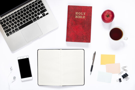 Top view of workspace and Holy Bible on white background