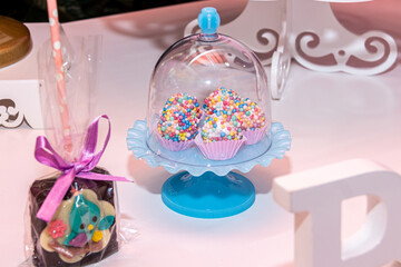 Table with children's birthday party decoration with objects and colorful candies
