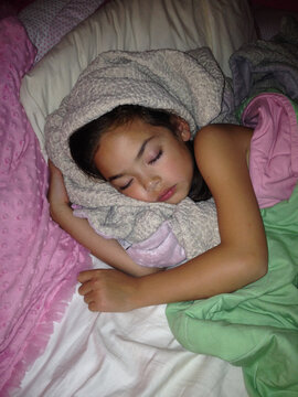 Child Sleeping Wrapped In Blankets