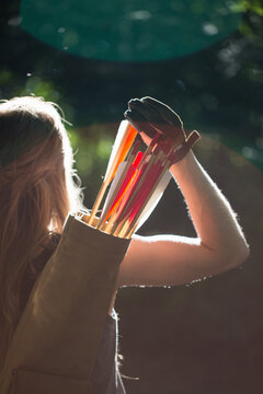 Woman taking an arrow from the quiver, back view