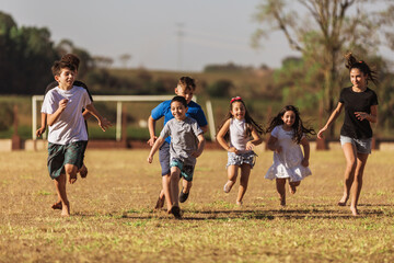 Obraz na płótnie Canvas Children on soccer field running and playing