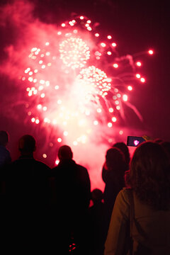 Young woman taking a photo of fireworks