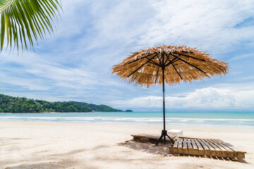 Beach Umbrella made of palm leafs on a perfect white beach in front of Sea in Phuket, Thailand.