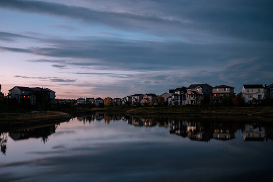 Homes back onto a still pond at dusk