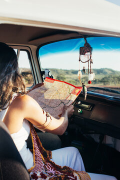 On The Road - Couple Sitting in White Camper Van and Studying Roadmap
