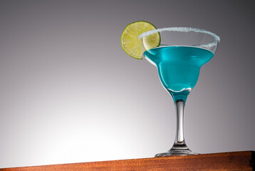 Blue Margarita Cocktail on a Wooden Surface With Gradient Background
