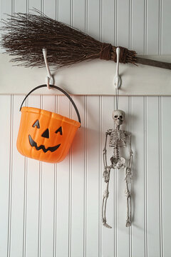Toy skeleton and candy bucket hanging on coat hook