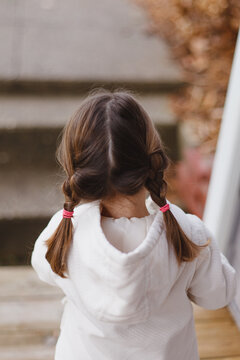 A young girl with double braids walking outside in the fall