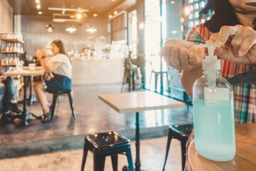 Fototapeta na wymiar Blue alcohol gel bottle for hand cleaning to prevent the spreading of the Corona virus (Covid-19), Place the entrance service for customers in the cafe. Healthcare concept.