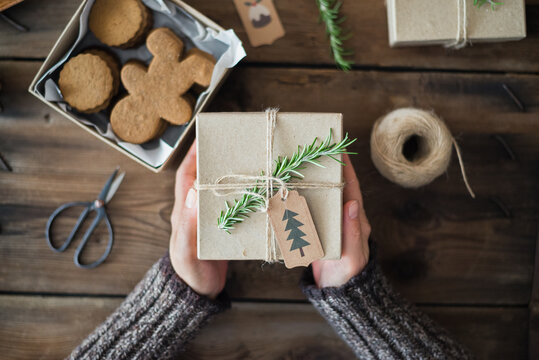 Woman holding gift-wrapped Gingerbread men cookies