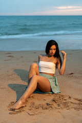 Fototapeta na wymiar Mujer joven adolescente modelo posando en un acantilado y en la playa. Chica vestida elegante para modelo