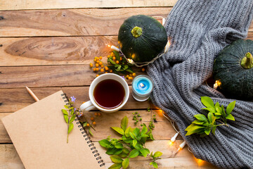 green pumpkin health care vegetation with hot tea healthy drinks ,notebook and knitting wool scarf of lifestyle woman relax autumn season arrangement flat lay style on background wooden