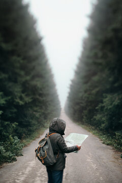Traveller holding a map in the middle of the road