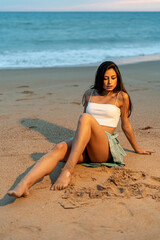 Fototapeta na wymiar Mujer joven adolescente modelo posando en un acantilado y en la playa. Chica vestida elegante para modelo