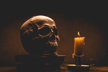 Still life type a scene with human skull and candle