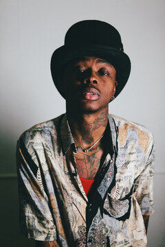 Stylish tatooed black model with top hat.