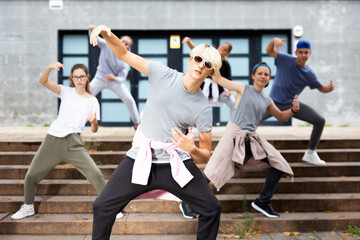 Teenagers boy and girls performing hip hop at city street