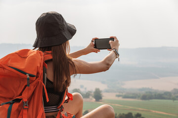 adventurous woman sitting on rock in a mountain