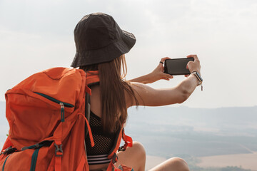 adventurous woman sitting on rock in a mountain