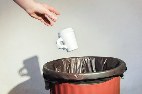 Disposable paper cup thrown away into thrash