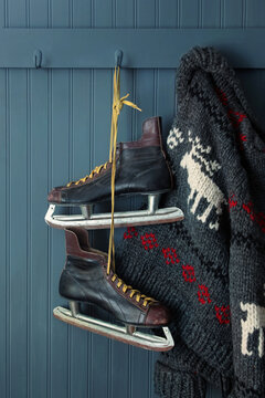 Men's vintage skates and sweater hanging on hooks