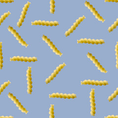 Obraz premium Fusilli pasta random flat lay on blue background without shadow. can be used as raw pasta background, poster, banner not pattern.