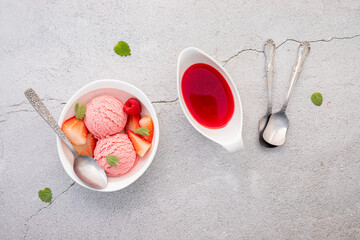 Strawberry  ice cream flavour in white  bowl setup on concrete background . Summer and Sweet menu concept.