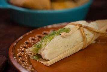 Tamales mexicanos hoja de maiz salsa tomatillo verde picantes chile carne platillo latino ingredientes envuelto relleno ancestral tradiciones día de muertos candelaria close-up