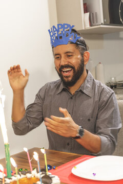 Retrato joven hombre mexicano festajeando en casa cumpleaños con pastel