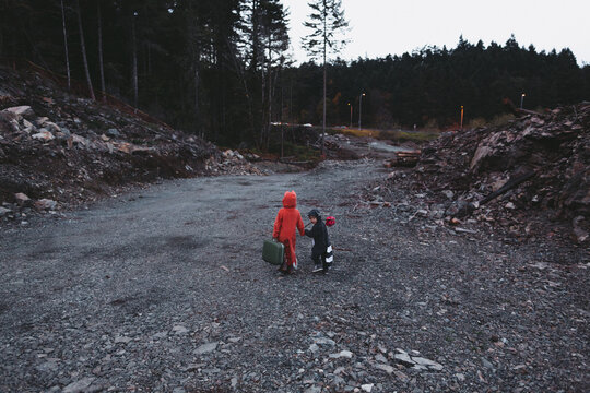 Kids dressed up like fox and raccoon walking away from destroyed home