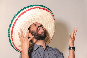 Retrato de hombre joven mexicano hispano latino con sombrero gritando con felicidad emoción dia de...