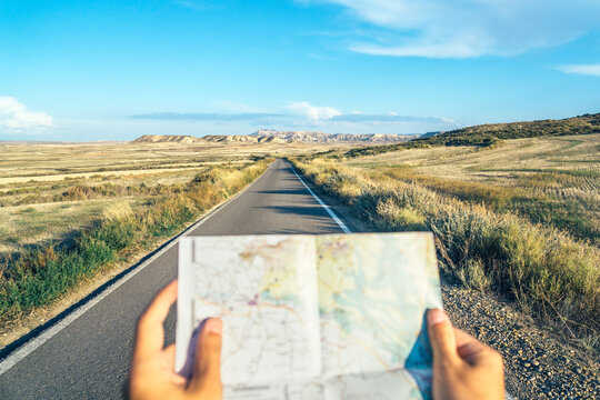 Hands holding a map on the road