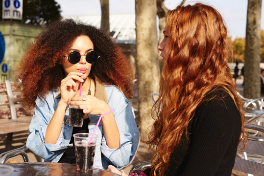 two women drinking oda at the urban park