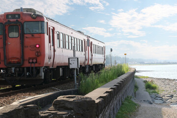 Obraz premium 海岸沿いを走るローカル電車と青空