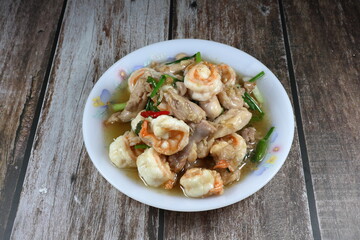 Fried and stirred fresh peeled shrimp, chopped chicken thigh, chilly and spring onion on the plate. Hot and spicy street food menu in Asia. 