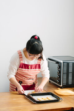 Young Chinese woman baking cookies