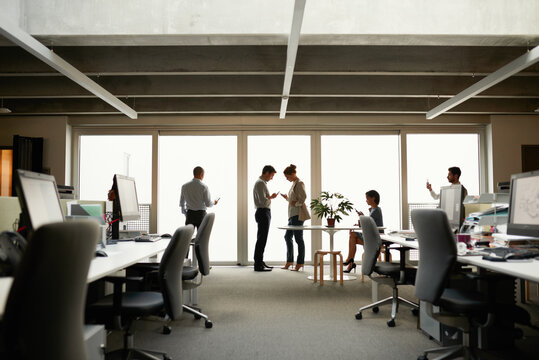 Silhouette of business group in office interior using wireless technology