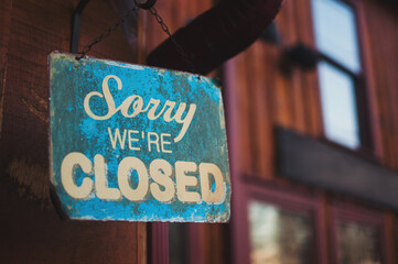 A sorry we're closed sign outside of a shop