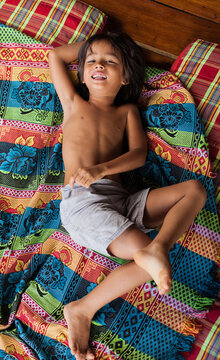 Cute little boy playing on colorful mattress.