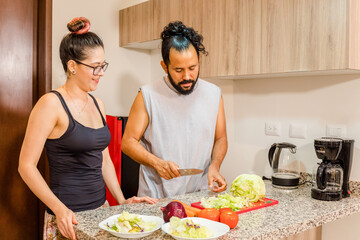 Pareja de mexicanos preparando ensalda en casa vida saludable