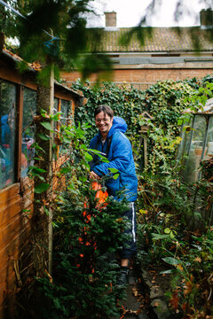 Man with learning disabilities using a leaf blower in a garden.